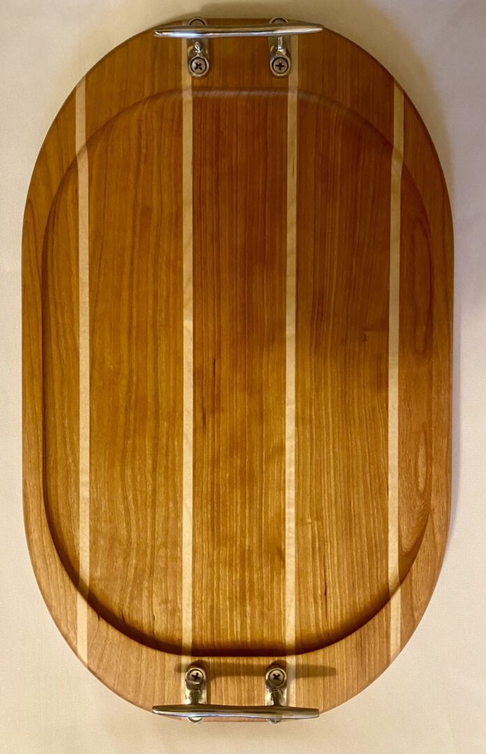 Wooden cutting board with metal handles.