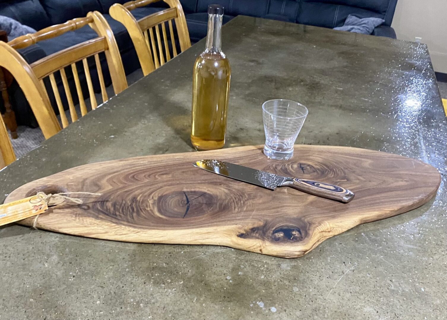 Wooden board with knife, bottle, and glass.