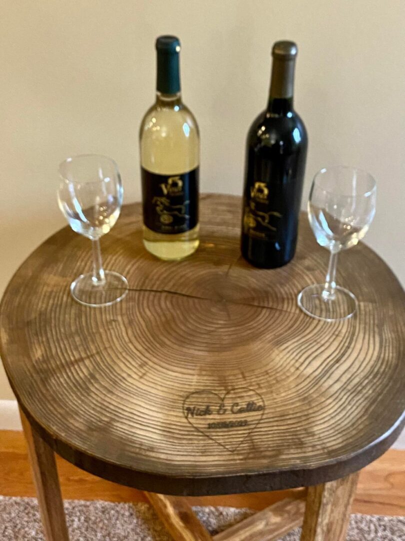 Wine bottles and glasses on wooden table.